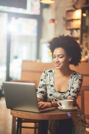 Mixed race woman having a coffee in coffee shopの写真素材