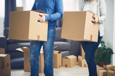 Couple relocating boxes in new apartment/ unpacking things