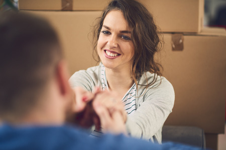 Man proposing to his girlfriend while moving to the new apartmentの写真素材