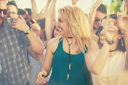 Crowd of people at music festival dancing and enjoying musicの写真素材