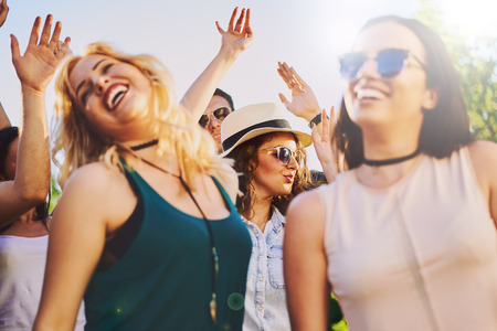 Crowd of people at music festival dancing and enjoying music