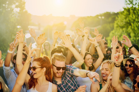 Crowd of people at music festival dancing and enjoying music