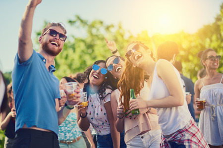 Friends taking selfie at outdoor party, sunlight at backgroundの写真素材