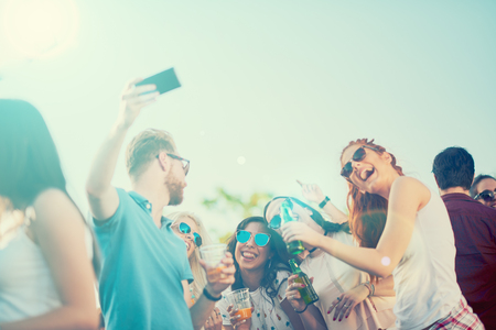 Friends taking selfie at outdoor party, sunlight at backgroundの写真素材