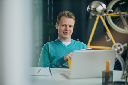 Businessman sitting and using tablet device at home officeの写真素材