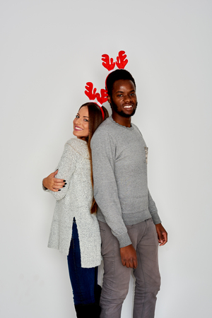 Couple posing with headband decoration on New Year/ white wall in backgroundの写真素材
