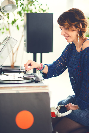 Woman listening vinyl at homeの写真素材