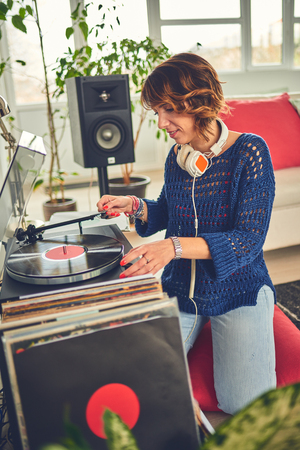 Woman listening vinyl at homeの写真素材