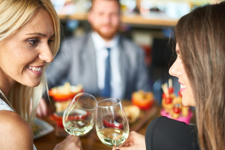 Business people meeting in modern restaurant, colleagues having dinner and take drink after workの写真素材