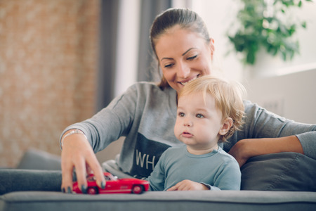 Mom playing with her son in cosy living roomの写真素材