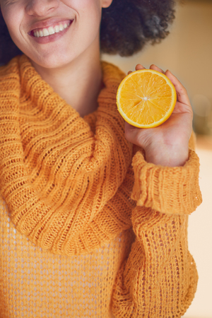 Close up of mixed race woman holding orangeの写真素材