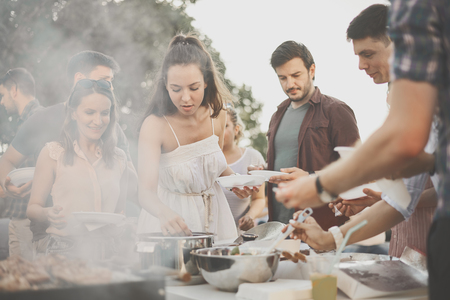 Group of people having meal at barbecue partyの写真素材