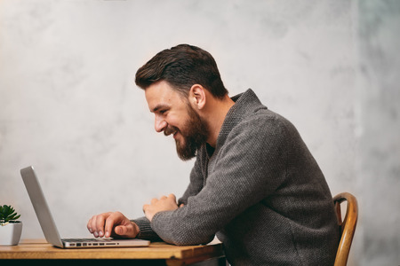Man using laptop for work and sitting in cafeの写真素材