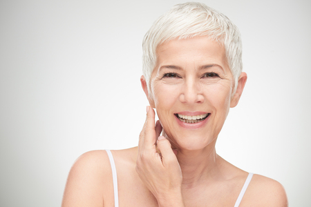 Portrait of beautiful senior woman in front of white background.の写真素材