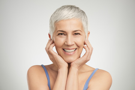 Portrait of beautiful senior woman in front of white background.の写真素材