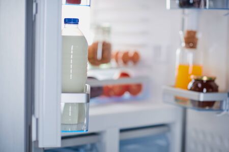 Opened frigde full of groceries. Selective focus on milk.の写真素材