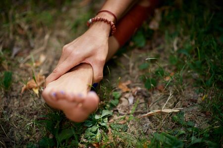 Close up of woman holding leg. Practicing yoga in nature concept.の写真素材