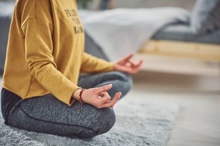 Close up of woman sitting on the mat in lotus posture.の写真素材