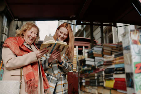 A grandmother and granddaughter choosing books at bookstore.の写真素材