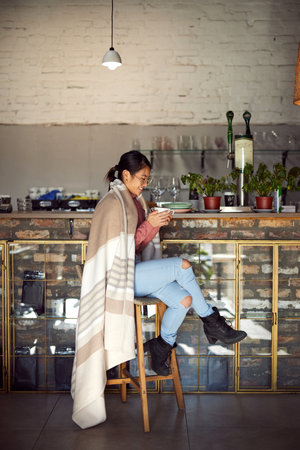 A happy multicultural girl sits in a bar and has her coffee.の写真素材