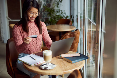 Asian woman shops online on her laptop.の写真素材