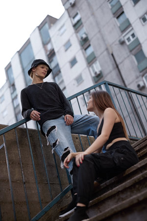 A teenage couple posing on the stairs in urban exterior.の写真素材