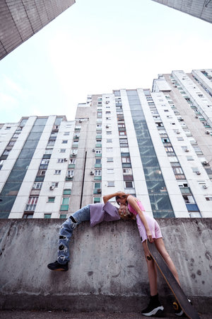 Teenage couple kissing and hugging in urban exterior surrounded by buildings.の写真素材