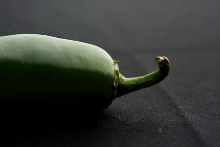 Close up of a jalapeÃ±o pepper and placed on a black cloth.の写真素材