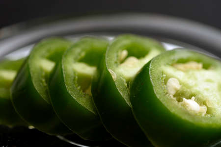 JalapeÃ±o pepper cut into slices and placed on a transparent glass plateの写真素材