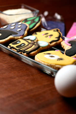Cookies made with butter and decorated with various figures, in the background in diffuse raw materials for their preparation, mentioning butter, flour, eggs and sugar.の写真素材