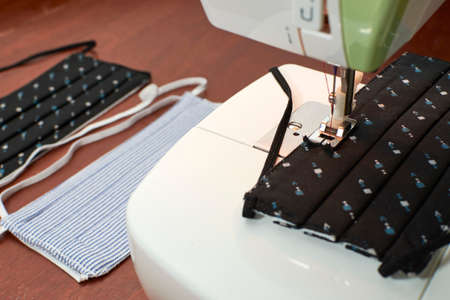 Sewing machine prepared to make face masks, on one side finished face masks