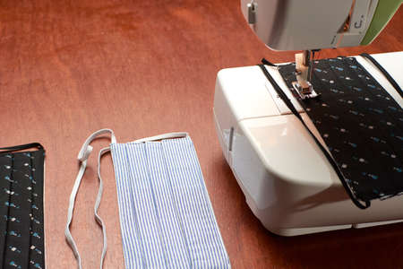 Sewing machine prepared to make face masks, on one side finished face masksの写真素材