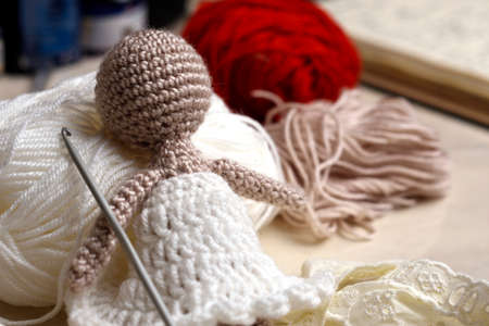 yarn doll made with needles to weave yarn, around it yarn of various colorsの写真素材