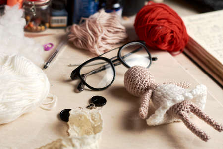 yarn doll made with needles to weave yarn, around it yarn of various colorsの写真素材