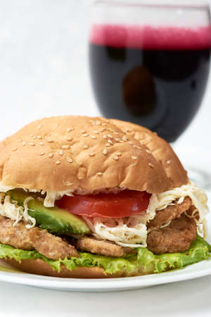 Simple commercial cake with chicken lettuce, tomato cheese and avocado, in the background a beet juiceの写真素材