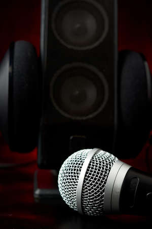 Microphone accompanied by a single speaker with large earphones, backlit diffuse backgroundの写真素材