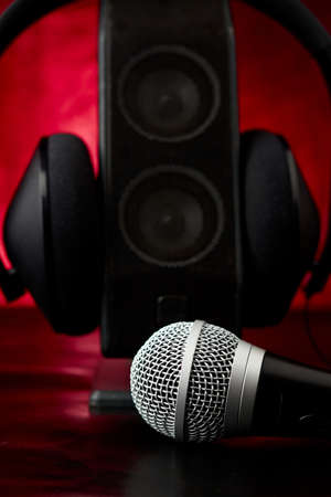Microphone accompanied by a single speaker with large earphones, backlit diffuse backgroundの写真素材