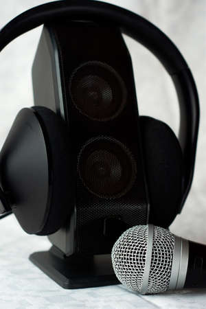 Microphone accompanied by a single speaker with large earphones, backlit diffuse backgroundの写真素材