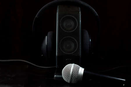 Microphone accompanied by a single speaker with large earphones, backlit diffuse backgroundの写真素材