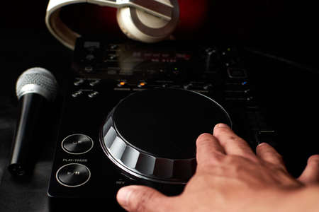 Compact disc jockey player with a microphone, in the background a professional headphonesの写真素材