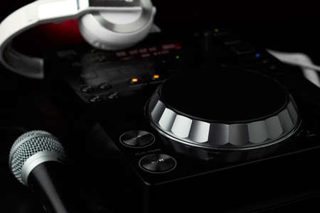 Compact disc jockey player with a microphone, in the background a professional headphonesの写真素材