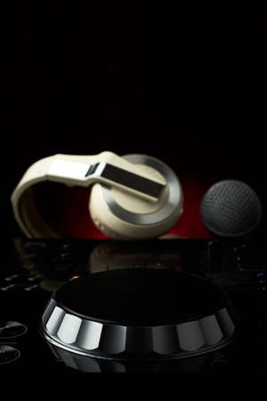 Compact disc jockey player with a microphone, in the background a professional headphonesの写真素材