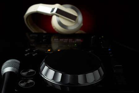 Compact disc jockey player with a microphone, in the background a professional headphonesの写真素材