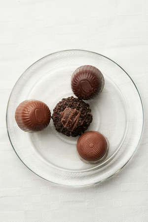 Multi-textruas chocolate, placed in a simple glass plateの写真素材