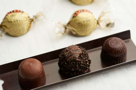 chocolate with various texture, placed in a piece of cardboard on a white surfaceの写真素材