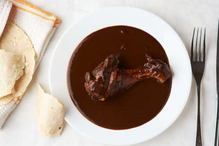 Chicken with mole, tortilla around ready to serve, Mexican tradition, placed on woodの写真素材