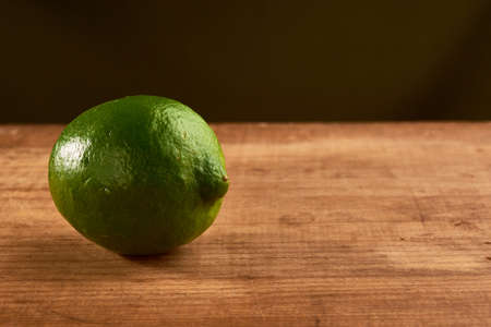Green lemon, placed on a wooden base