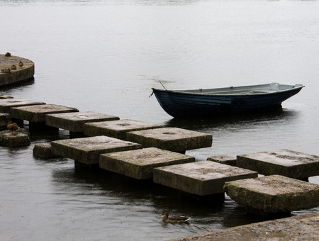 the wooden boat near a stone pierの写真素材