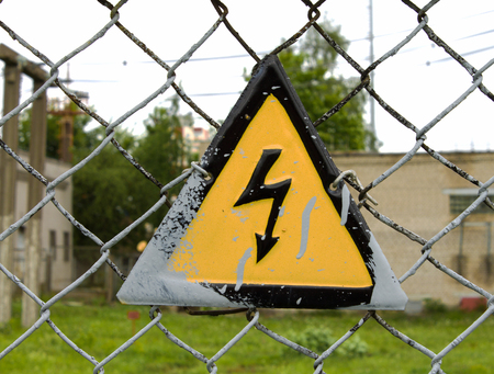 high-voltage wires, a sign on the fence the dangerの写真素材