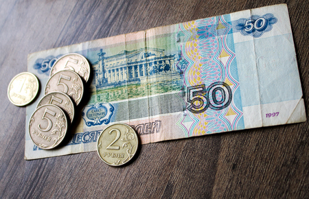 the Russian currency, the Russian money, rubles and coins on a wooden backgroundの写真素材